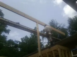 Carpenter setting a ridge beam over a new addition frame — Ice Dam Removal by Roofing Brothers in North Jackson