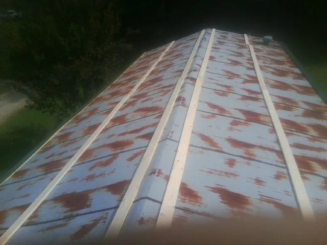 Rusted metal roof panels with new wood purlins before replacement — Storm Damage Roof Repair in North Jackson by Roofing Brothers