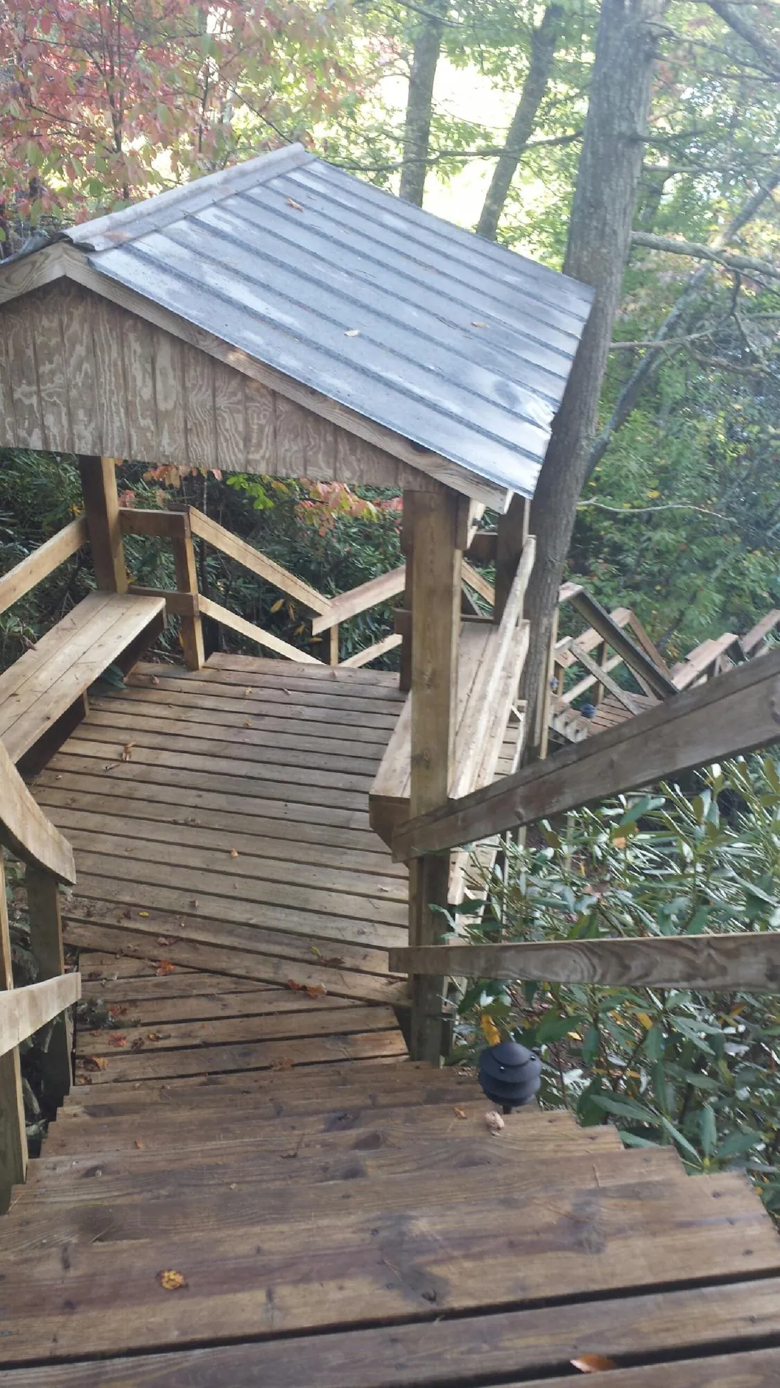 Metal roofed shelter over wooden steps on a wooded walkway — Skylight Repair & Installation work by our crew in North Jackson