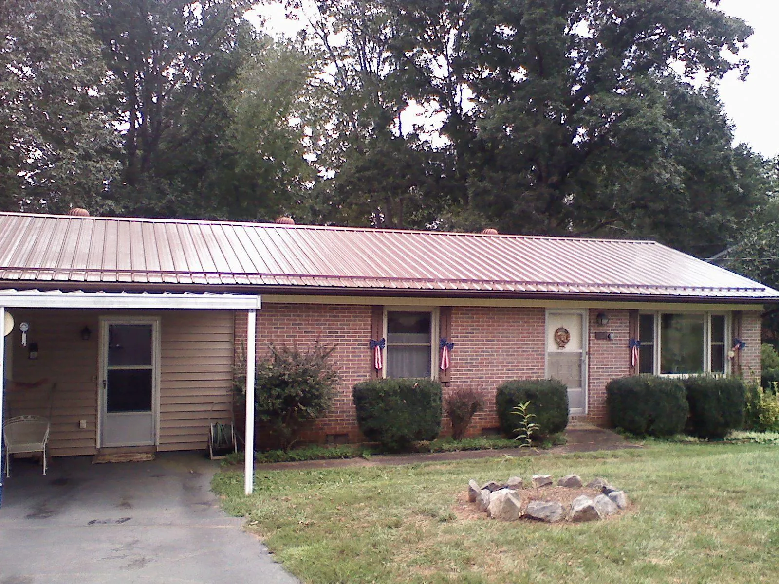 Bronze metal roof and carport on a brick ranch home — Roof Repair work by our crew in North Jackson